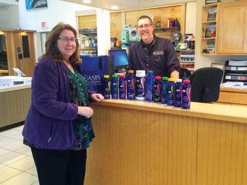 A retailer carrying Haviland Pool and Spa Products' line of pool care products, posing with a customer. 