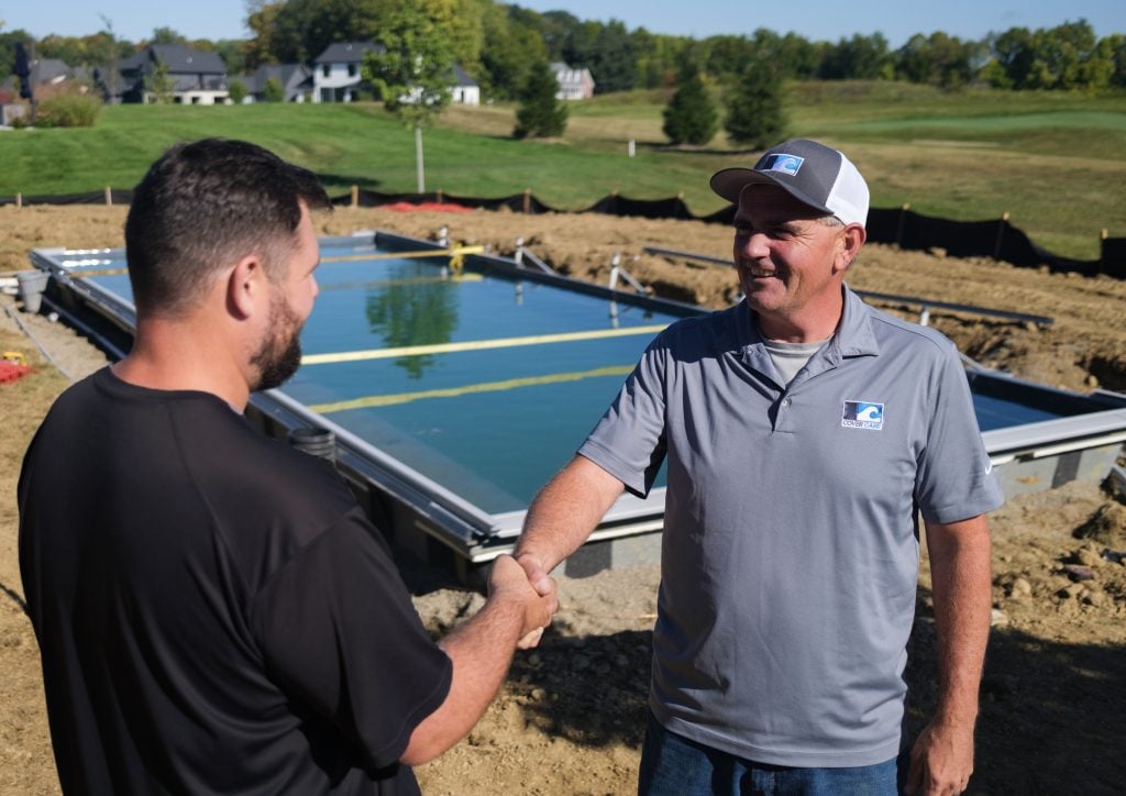 CoverCare tech helping pool builder install a pool cover.