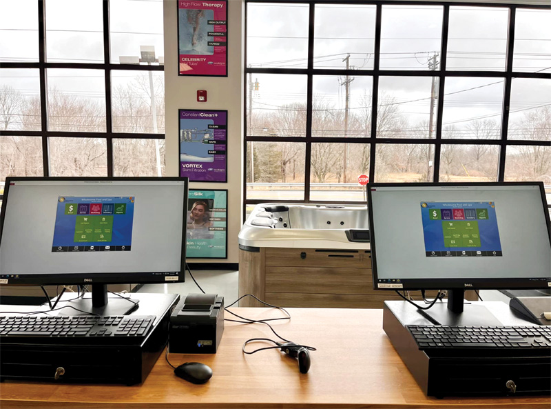 Two desktops from cashier's point of view, overlooking window in a hot tub store.